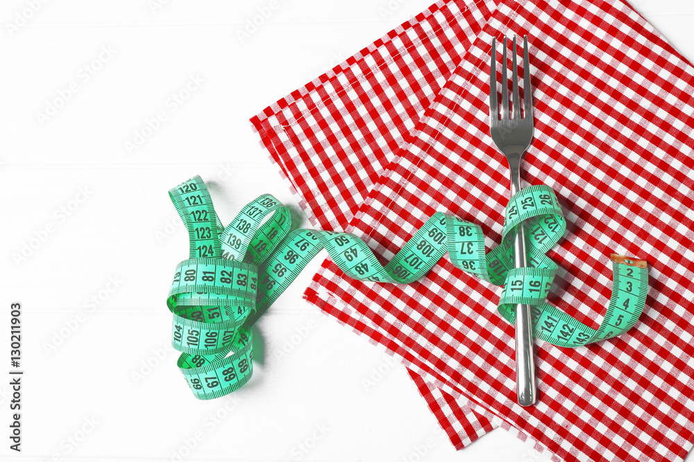 Fototapeta premium Fork and measuring tape on red napkin