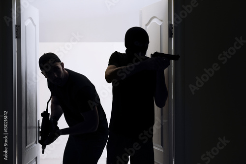 Fotografia Thieves with gun entering the room