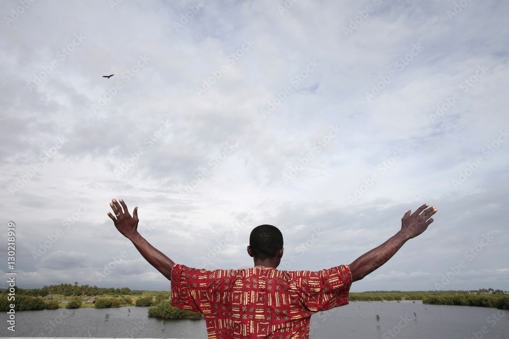 African man watching the sky, Ouidah, Benin, West Africa African man watching the sky, Ouidah, Benin, West Africa