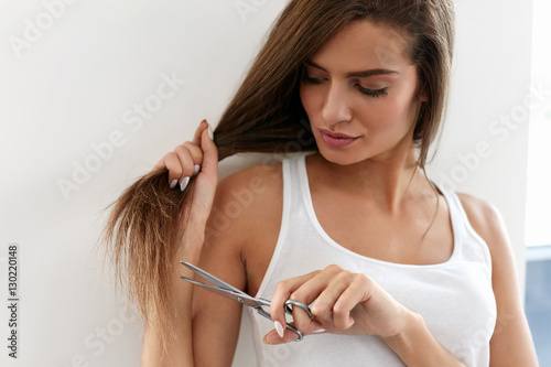 Beautiful Woman Cuts Split Ends Of Long Hair With Scissors