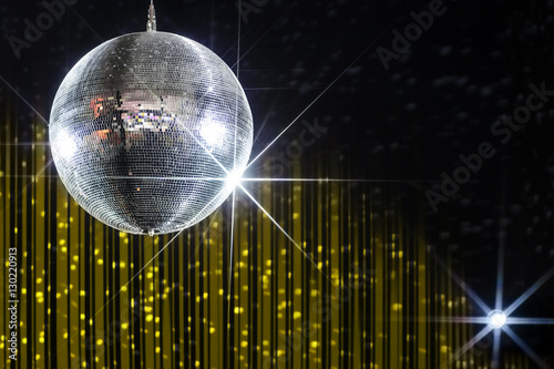 Party disco ball with stars in nightclub with striped yellow and black walls lit by spotlight, nightlife entertainment industry