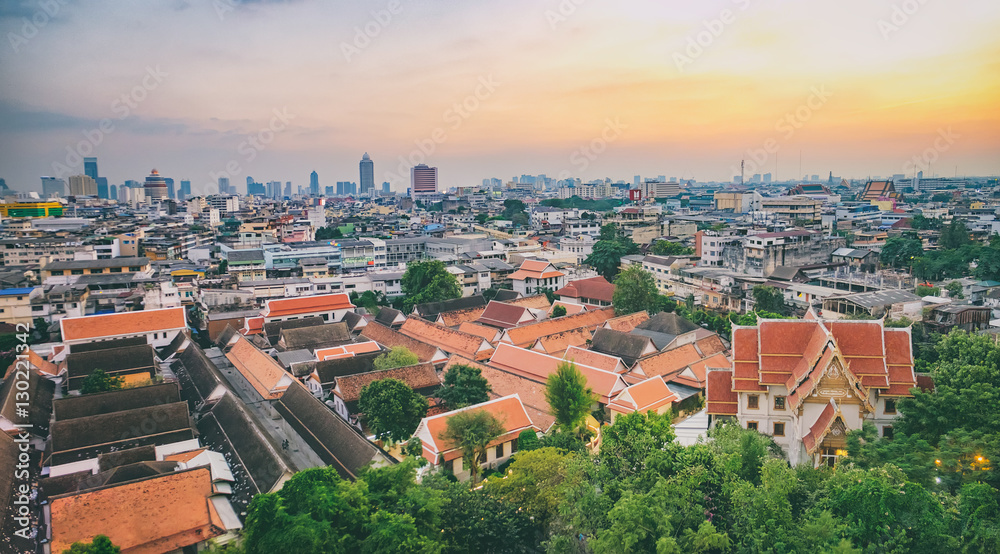 Traditional architecture of Wat Saket from the height of bird flight. View of Bangkok from Golden Mountain during a colorful sunset, Thailand.