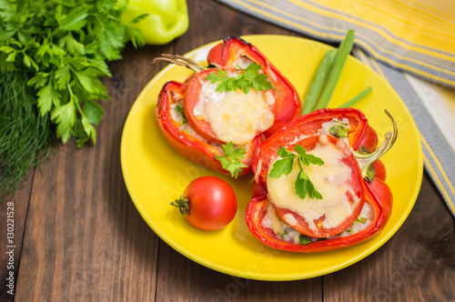 Stuffed bell peppers with rice and cheese. Wooden background. Close-up