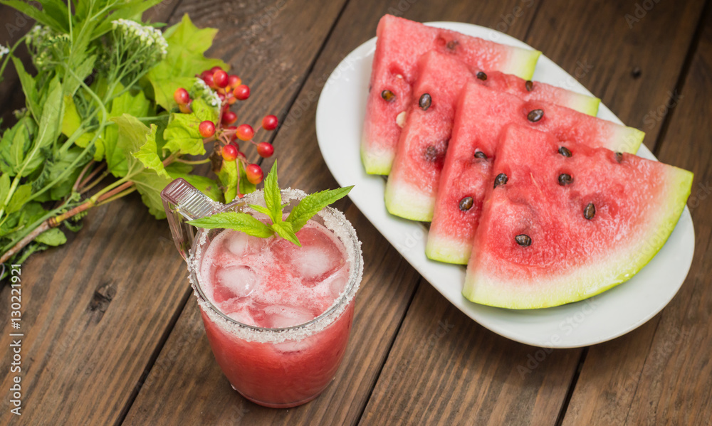Fresh watermelon juice on a background of slices wooden table. Close-up Fresh watermelon juice on a background of slices wooden table. Close-up