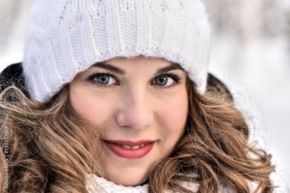Girl in a white knitted hat for a walk in the winter forest Girl in a white knitted hat for a walk in the winter forest