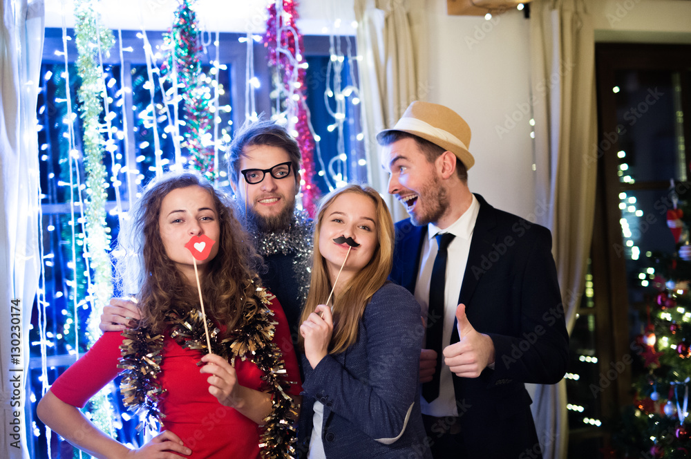 Hipster friends celebrating New Years Eve together, photobooth p - obrazy, fototapety, plakaty 