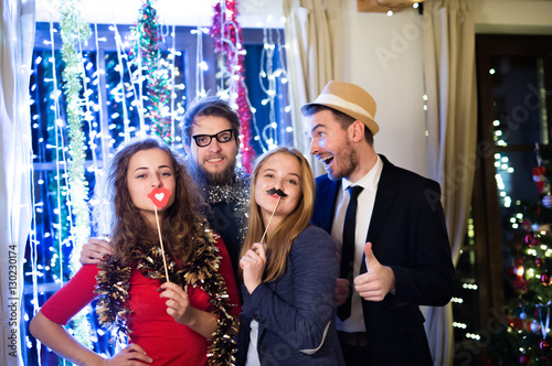 Hipster friends celebrating New Years Eve together, photobooth p