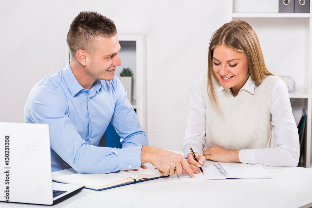 Businesswoman and businessman sitting in office and working together.
Businesswoman and businessman sitting in office and working together.