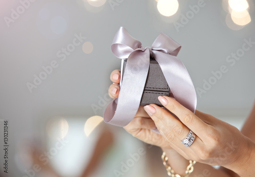 Female hands holding small elegant gift with ribbon
