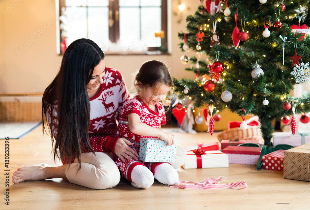 Fototapeta premium Young mother with daugter at Christmas tree at home.
