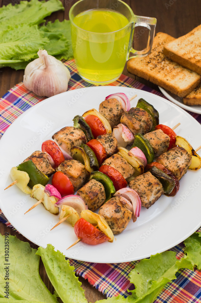 Skewers of chicken and vegetables on wooden . Rural background. Close-up Skewers of chicken and vegetables on wooden . Rural background. Close-up