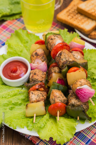 Skewers of chicken and vegetables on wooden . Rural background. Close-up