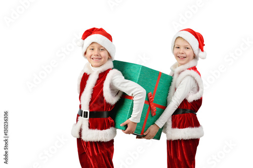 Adorable happy boys in santa clothes holding Christmas gift box. Isolated white background.