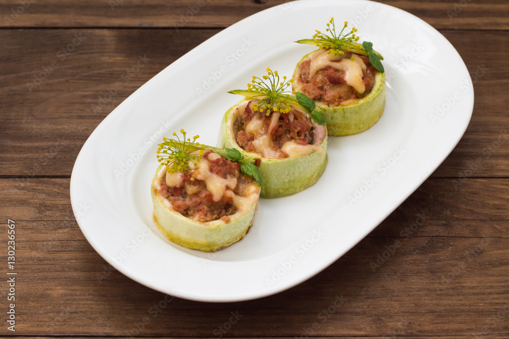 Courgettes stuffed with tomatoes, minced meat, cheese and spices. Wooden background. Top view. Close-up Courgettes stuffed with tomatoes, minced meat, cheese and spices. Wooden background. Top view. Close-up