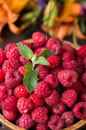 Fresh raspberry in wooden plate. Rural background. Close-up