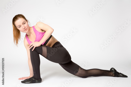 Attractive fitness woman preforming stretching exercise.