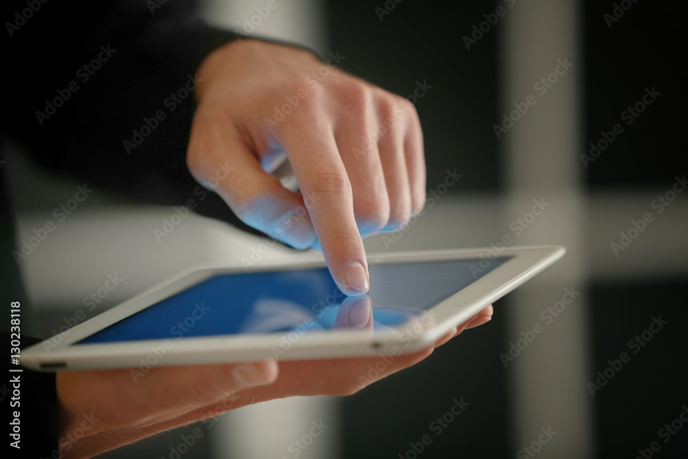 Male finger touching tablet screen on blurred background Male finger touching tablet screen on blurred background