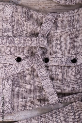 Knitted gray cardigan with a belt close up.