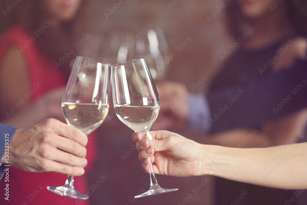 Female and male hands toasting with glasses of white wine, closeup