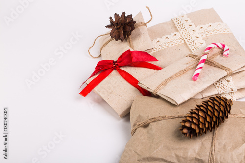Christmas boxes with gifts tied with ribbon and pine cones isolated on white background