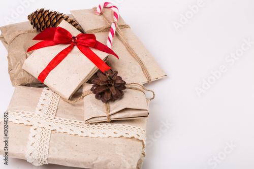 Christmas boxes with gifts tied with ribbon and pine cones isolated on white background