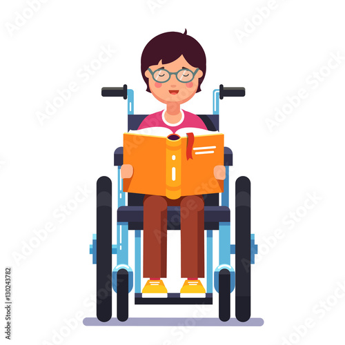 Disabled boy sitting in a wheelchair and reading