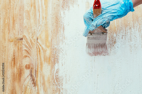 closeup hand use brush paint white on wood surface