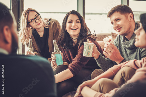 Canvas Print Group of multi ethnic young friends having fun in home interior