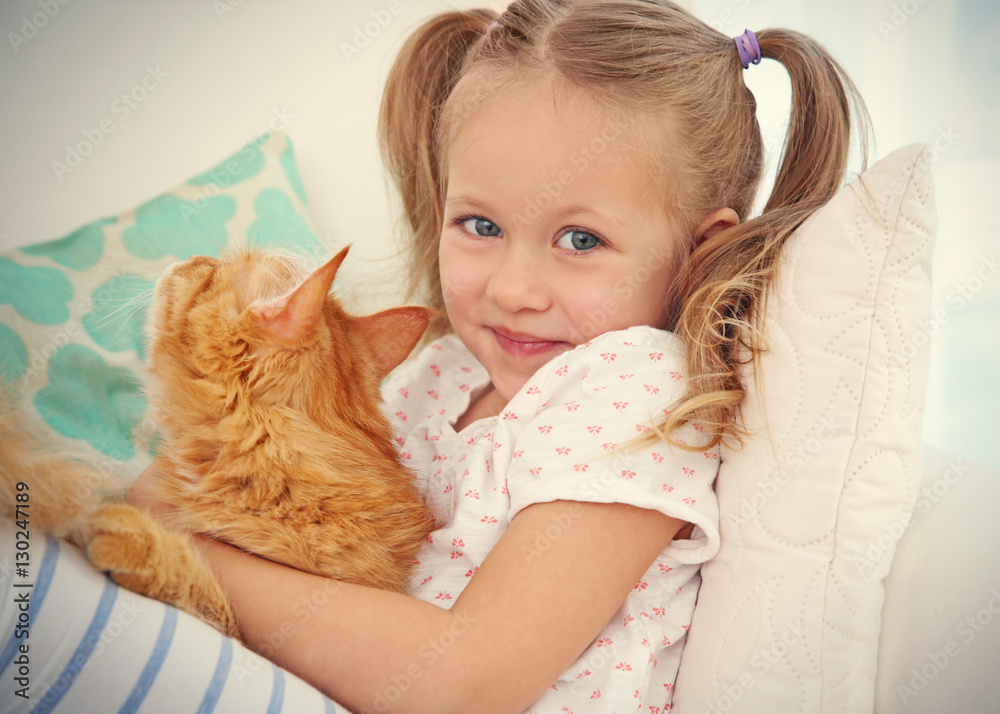 Cute little girl with red cat at home, close up