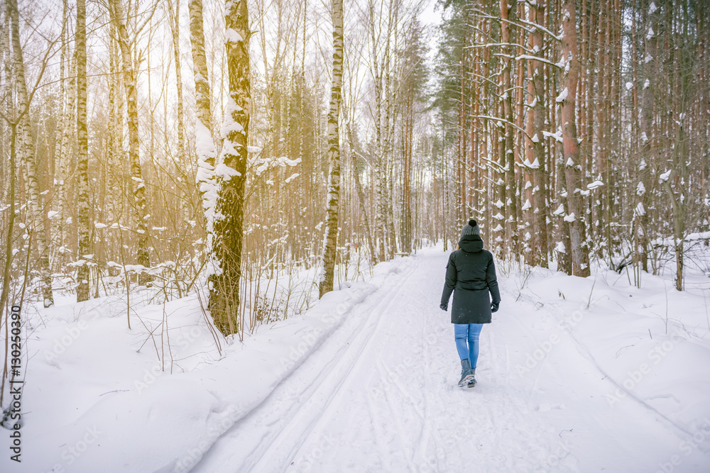 girl walking on the road in winter Russian forest