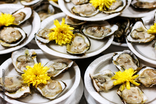 Served portion of fresh oysters on plastic plates