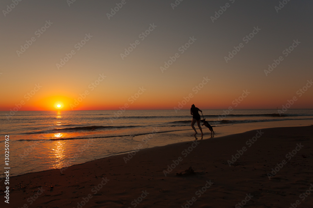 Girl with dog in the sunset