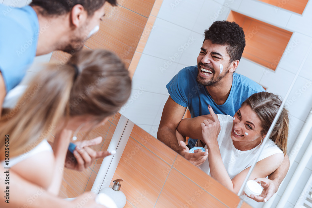 Naklejka premium Couple in bathroom with face cream