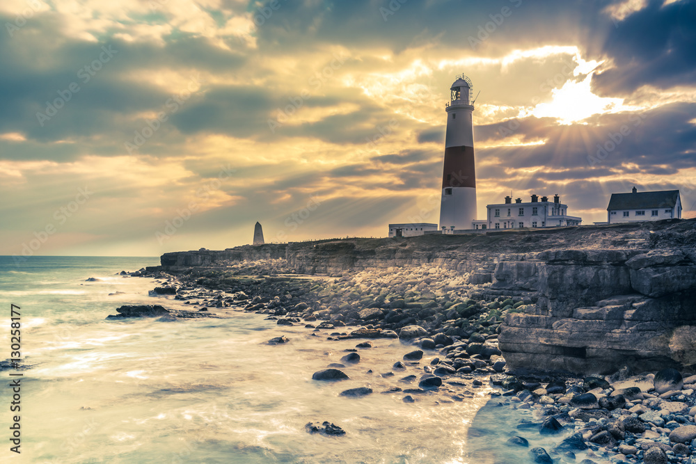 Dramatic sunset with iconic lighthouse on coast