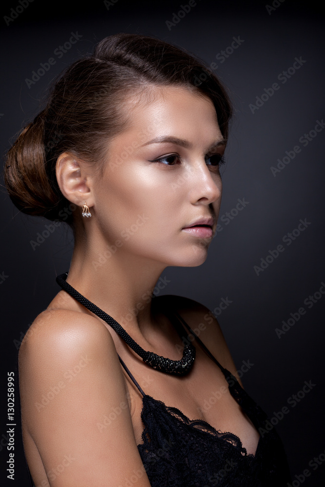 Portrait of a teenage girl on a dark background.