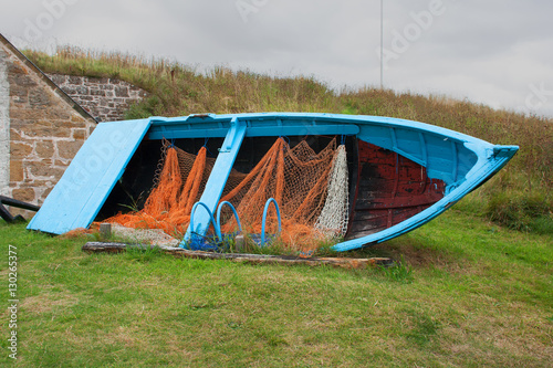 Open boat with small mesh nets and lobster pots on display