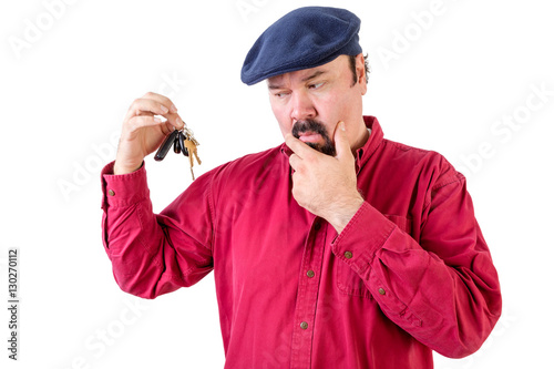 Confused man frowning at a bunch of car keys