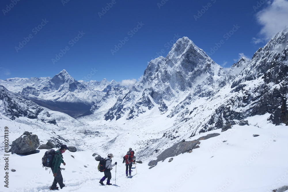 Trekkers walking over Cho La Pass with Ama Dablam on left and Arakam Tse on right, Solukhumbu District, Nepal, Himalayas Trekkers walking over Cho La Pass with Ama Dablam on left and Arakam Tse on right, Solukhumbu District, Nepal, Himalayas