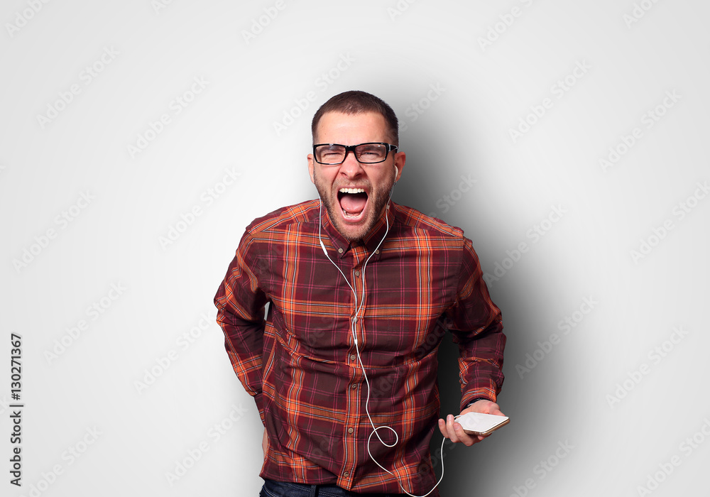 Fototapeta premium Shout, the young guy in the shirt and headphones