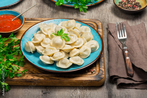 A dish with ravioli on the wooden board