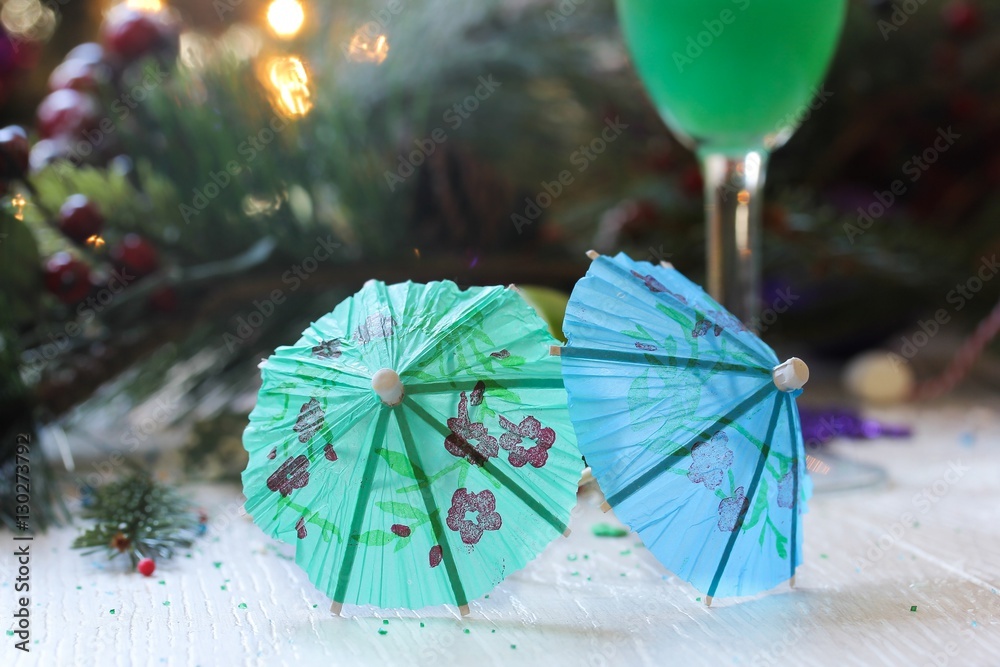 Cocktail umbrella on festive background, selective focus