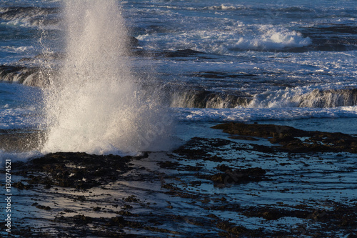 waves crashing on the lava rock bluffs