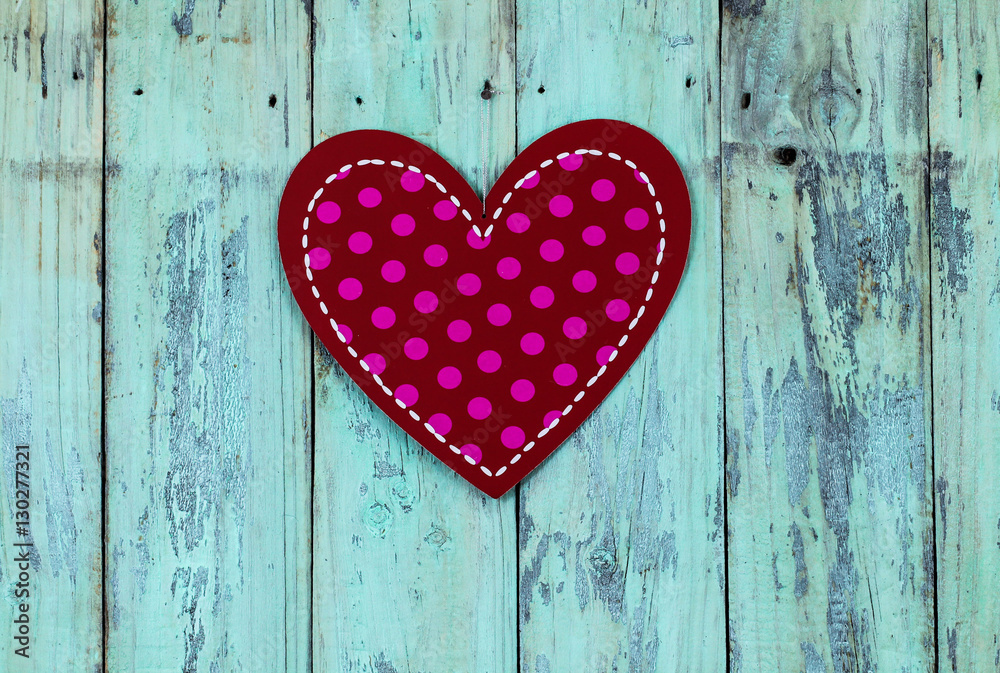 Large red polka dot heart hanging on wood door