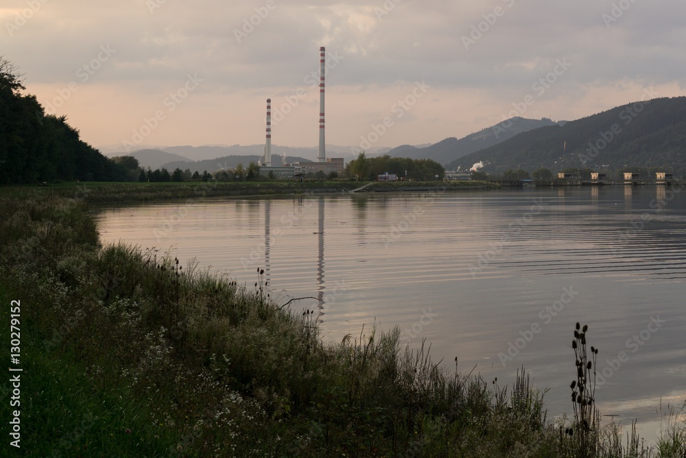 Chimneys of town and clouds with reflections in water reservoir on river Vah. Slovakia Chimneys of town and clouds with reflections in water reservoir on river Vah. Slovakia