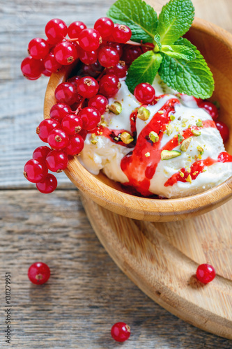 Ice cream with berry sauce and pistachio.