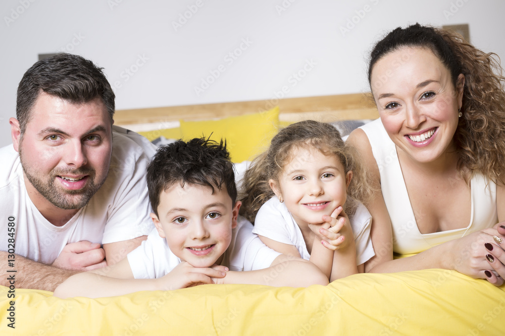 family, children and home concept - happy family with two kids under blanket at home family, children and home concept - happy family with two kids under blanket at home