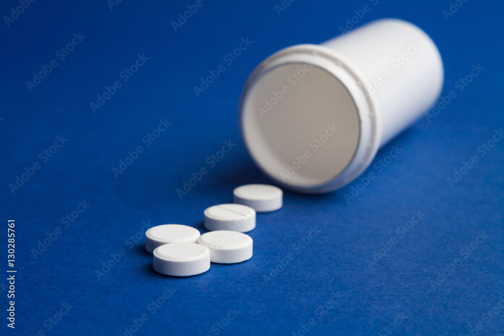 white pills arrow and pill bottle on blue background medicine pharmacy health