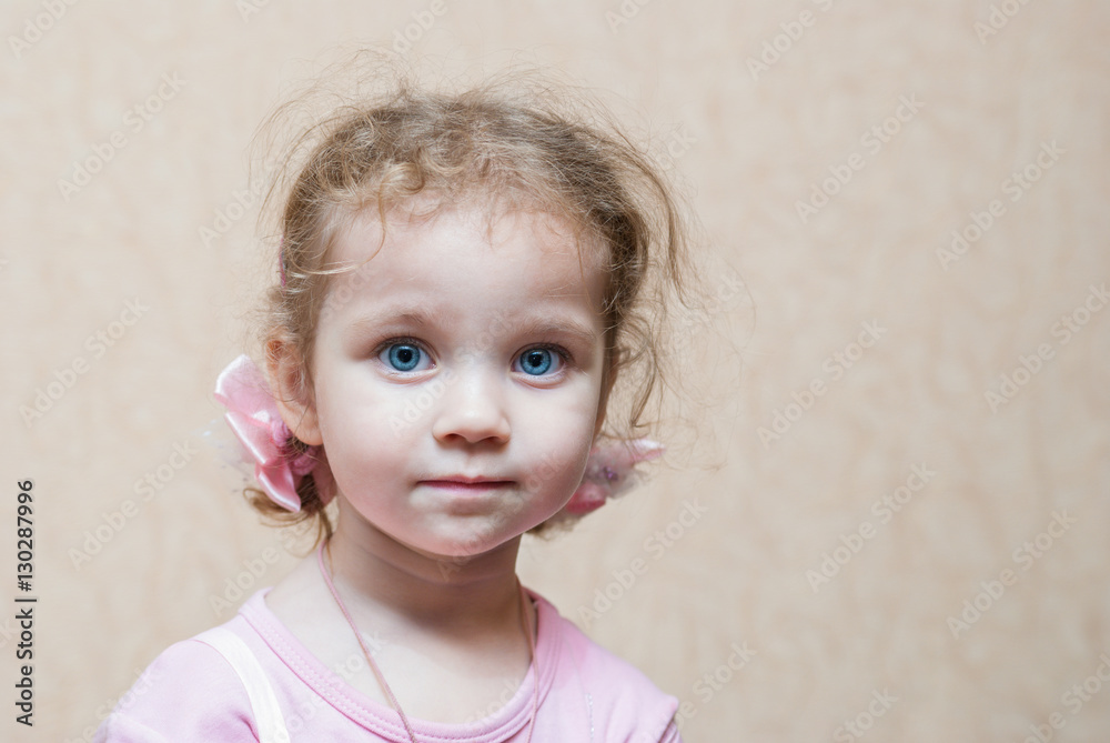 Fototapeta premium Portrait of a little girl with big blue eyes and curly hair