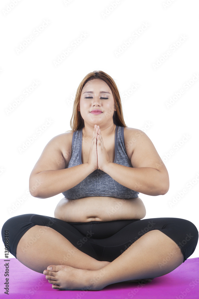 Overweight woman practicing yoga on studio Overweight woman practicing yoga on studio