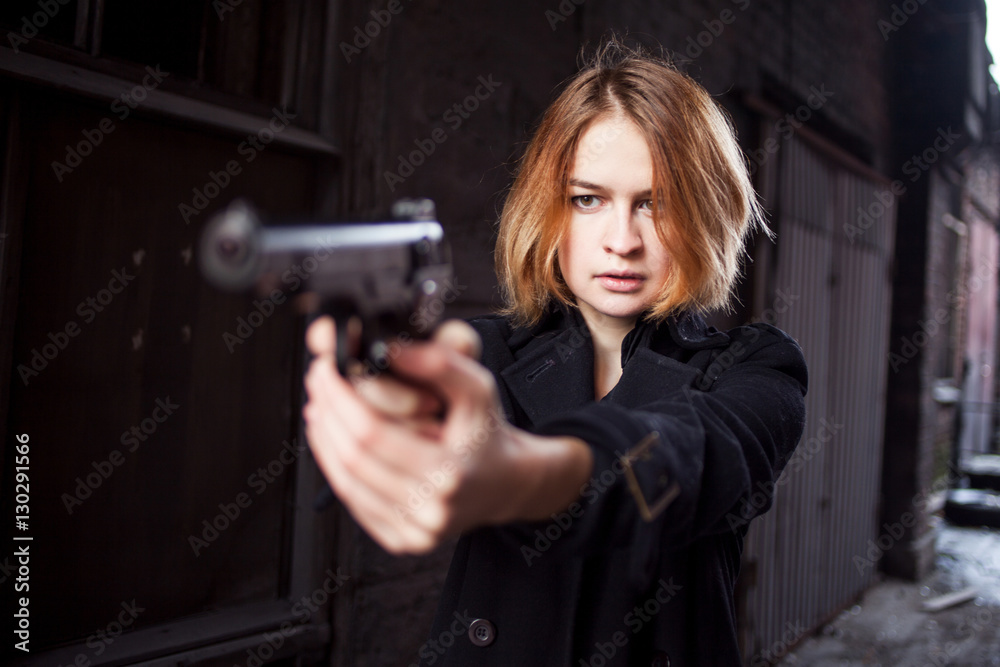 Woman pointing a gun. Mafia girl shooting at someone on the street. Woman pointing a gun. Mafia girl shooting at someone on the street.